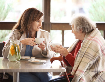 caregiver talking to old woman while sitting