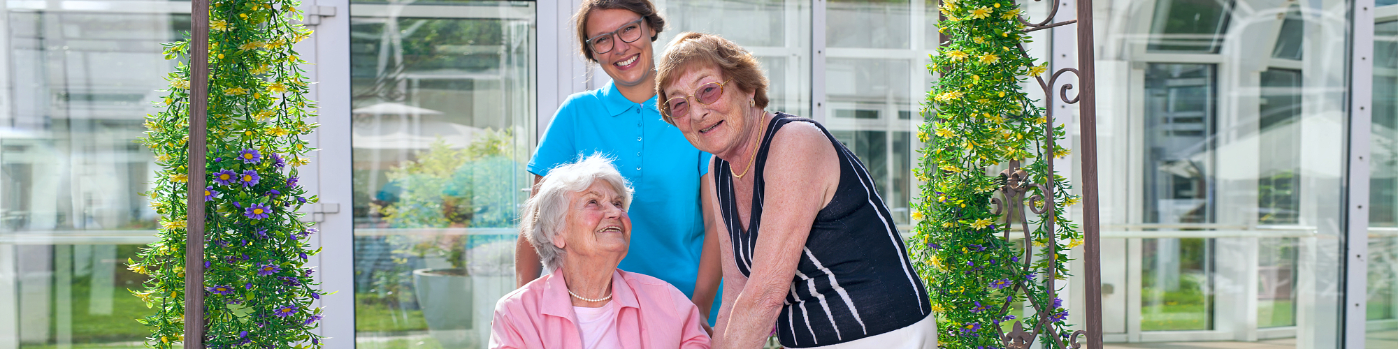 two seniors and caregiver smiling